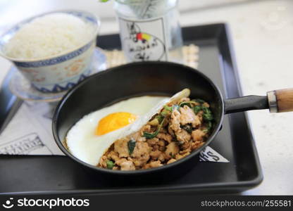 Stir fried pork and basil served with rice and fried egg , Thai food