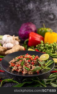 Stir-fried pork basil on banana leaves in a black dish. Thai food.