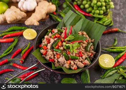Stir-fried pork basil on banana leaves in a frying pan. Thai food.