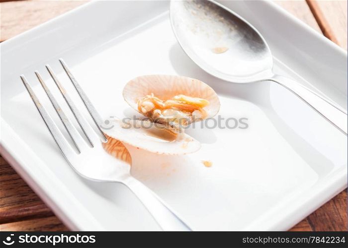 Stir fried roasted chili paste clam on white dish with spoon and fork