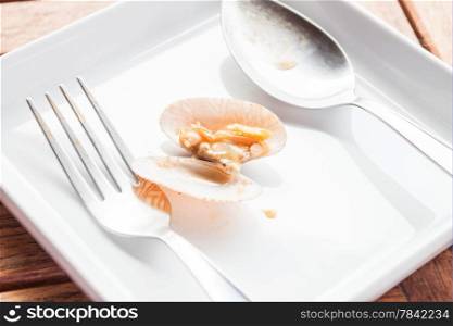 Stir fried roasted chili paste clam on white dish with spoon and fork