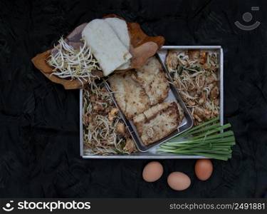 Stir fried soft turnip cake or Fried radish cake (chai tow kway) with bean sprout and chives. Thai - Chinese food called Kanom Pak kad or Char Koay Kak, Top view, Selective focus.