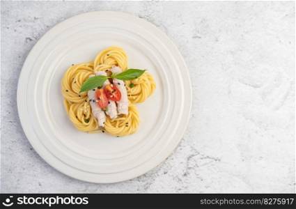 Stir-fried spaghetti and pork, beautifully arranged in a white plate.