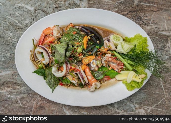 Stir-Fried Spicy seafood with herbs and spices served on white plate. Authentic thai food. Top view, Selective focus.