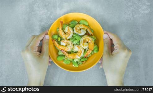 Stir-Fried Twisted Cluster Bean with Shrimps. top view of Stir-Fried Twisted Cluster Bean with Shrimps/Butter Bean on orange dish