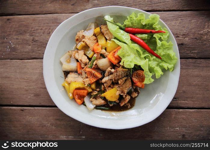 Stir fry chicken with black pepper on wood background