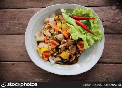 Stir fry chicken with black pepper on wood background