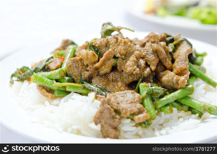 stir fry chinese cowpea and pork with curry sauce over rice