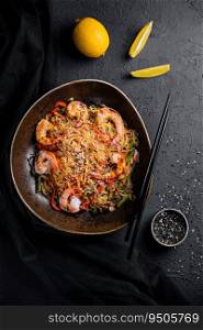 Stir fry noodles with vegetables and shrimps in black bowl