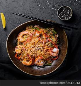 Stir fry noodles with vegetables and shrimps in black bowl