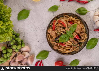 Stir fry the spaghetti put the pork in a bowl with pepper seeds, chilies, garlic, tomatoes, lettuce, lemon, and basil.