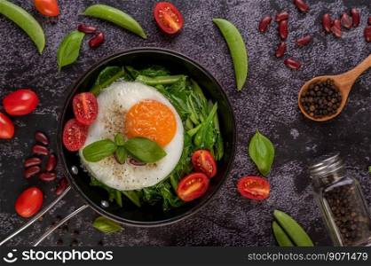 Stir kale and fried egg in a pan with tomatoes and red beans.