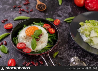 Stir kale and fried egg in a pan with tomatoes and red beans.