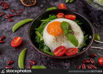 Stir kale and fried egg in a pan with tomatoes and red beans.