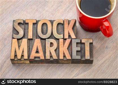 stock market word abstract in vintage letterpress wood type with a cup of coffee