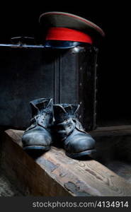 Stock photo: an image of old black boots, a hat and a suitcase