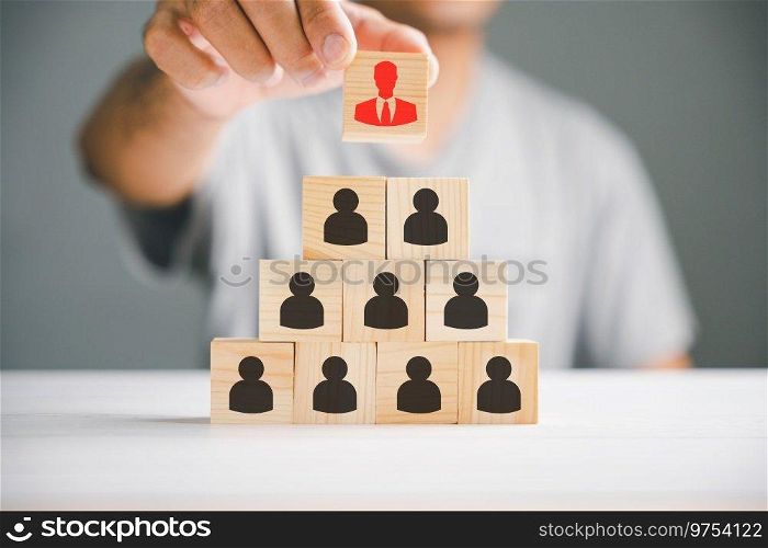Stock photo illustrating human resources talent management and recruitment. Person icons on wooden cube block symbolize teamwork and organization. Woman leadership concept in a business setting.. A red manager icon that stands out distinctively from a group of staff employee icons displayed