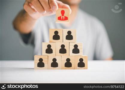 Stock photo illustrating human resources talent management and recruitment. Person icons on wooden cube block symbolize teamwork and organization. Woman leadership concept in a business setting.. A red manager icon that stands out distinctively from a group of staff employee icons displayed