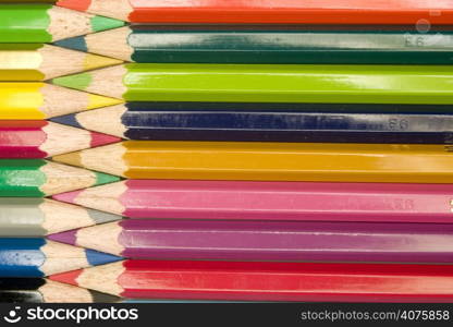 Stock photograph of brightly colored pencils forming aasymmetric pattern.