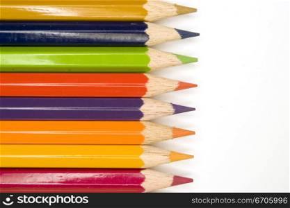 Stock photograph of brightly colored pencils forming aasymmetric pattern.