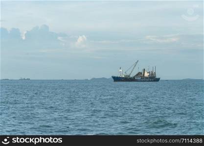 stock tanker ship at sea on a background of clouds blue sky.
