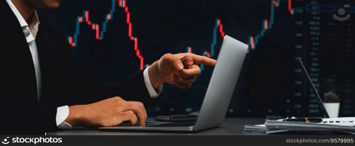 Stock trading investor finger pointing on dynamic financial data graph on monitor. Businessman or broker with analytic thinking analyzing data for stock market exchange trading company. Trailblazing. Stock trading investor monitoring dynamic financial data graph. Trailblazing