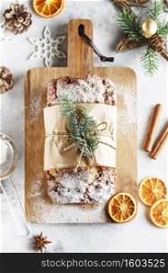 Stollen is fruit bread of nuts, spices, dried or candied fruit, coated with powdered sugar. It is traditional German bread eaten during the Christmas season. New year prep. Holiday baking. flat lay