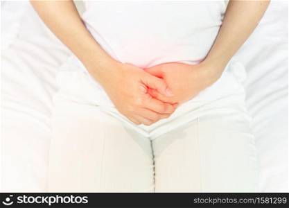 stomachache in young Asian woman sitting on bed in bedroom after wake up,Healthcare concept