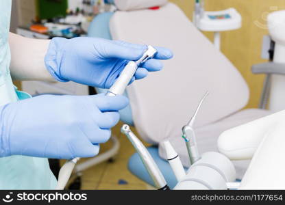 Stomatological instrument in dentists clinic. Doctor takes hand drill.. Stomatological instrument in dentists clinic. Doctor takes hand drill