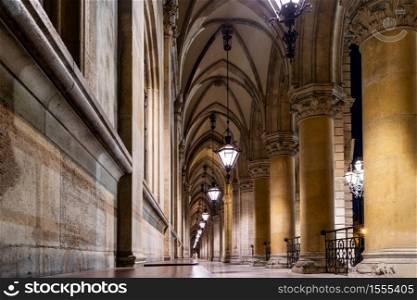 Stone arched perspective with ancient columns and vaulted ceiling with hanging old lamps in the temple in Vienna, Austria.. Arched perspective with columns and vaulted ceiling in the temple in Vienna.