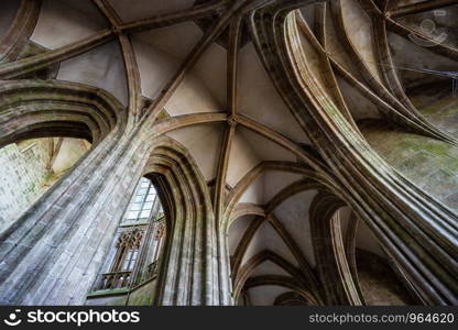 Stone arches within Mont Saint-Michel abbey / cathedral with a wide angle lens, Normandy, France. Stone arches within Mont Saint-Michel abbey