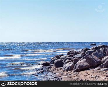 Stone boulders on the beach. Sunny summer day