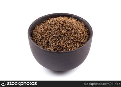 Stone bowl and pile of cumin seeds isolated on white background