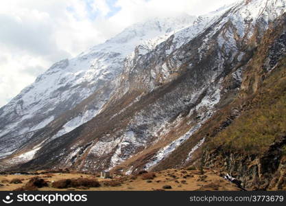 Stone building and snow mountain near Samdo in Nepal