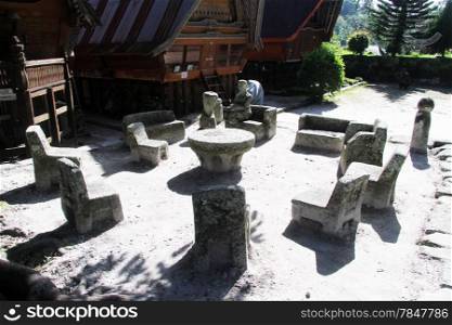Stone chairs near batak houses in Ambarita vvillage, Indonesia
