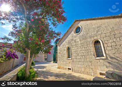 Stone church and flowers of Hvar island, town of Stari Grad, Croatia