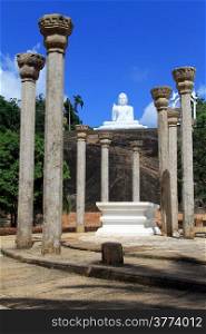 Stone columns and white Buddha in Mihintale, Sri Lanka