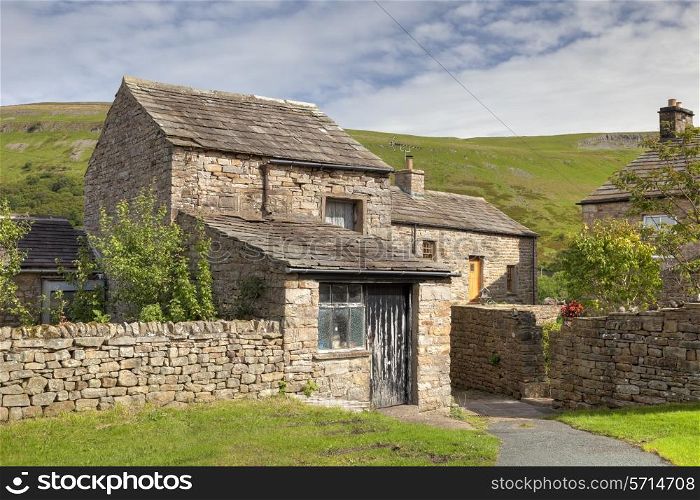 Stone cottage with barn in the Yorkshire Dales village of Muker, Swaledale, England.