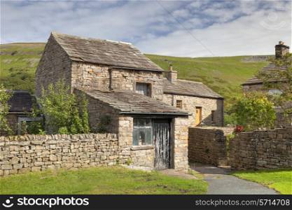 Stone cottage with barn in the Yorkshire Dales village of Muker, Swaledale, England.