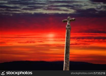 stone cross with the sunset as background