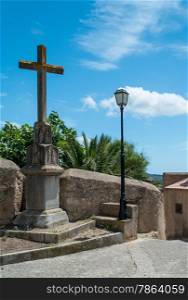Stone Crucifix and Lamppost with Blue Sky