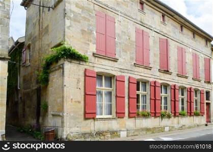 Stone faAade of france with shutters . Stone faAade of france with shutters of burgundy color in the city of Bar le Duc in Meuse FranAaise