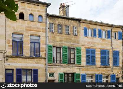 Stone facade of France with blue and green shutters . Stone facade of France with blue and green shutters in the city of Bar le Duc in Meuse FranAaise