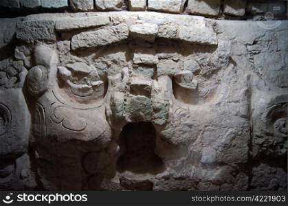 Stone face of mayan warrior in tunnel in Copan, Honderas
