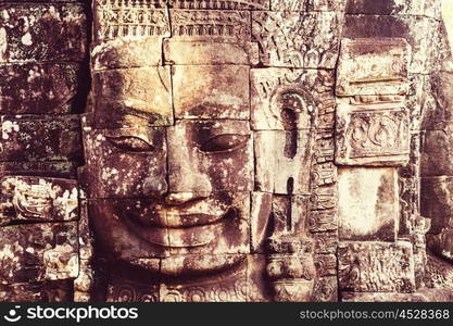 Stone faces of ancient Khmer culture temple of Bayon in Angkor area near Siem Reap, Cambodia