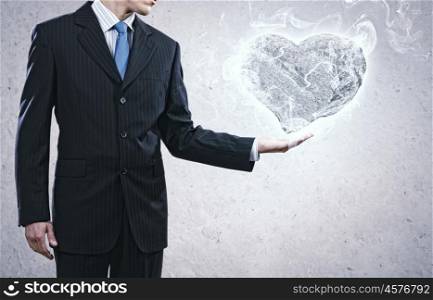 Stone heart. Businessman holding stone in shape of heart in palm