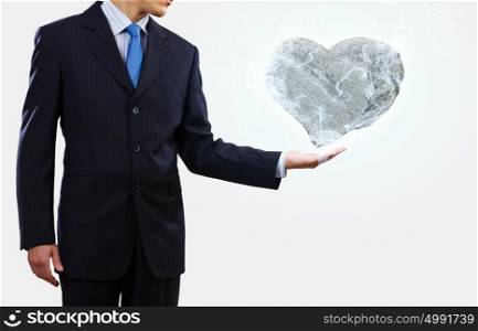 Stone heart. Businessman holding stone in shape of heart in palm