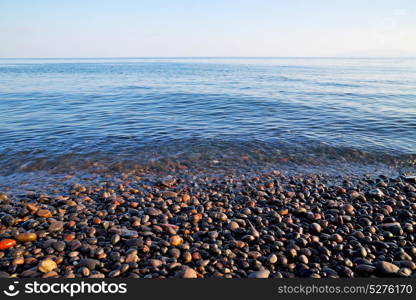 stone in the coastline sunrise and light ocean white sky