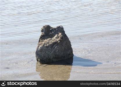 stone in the middle of a beach