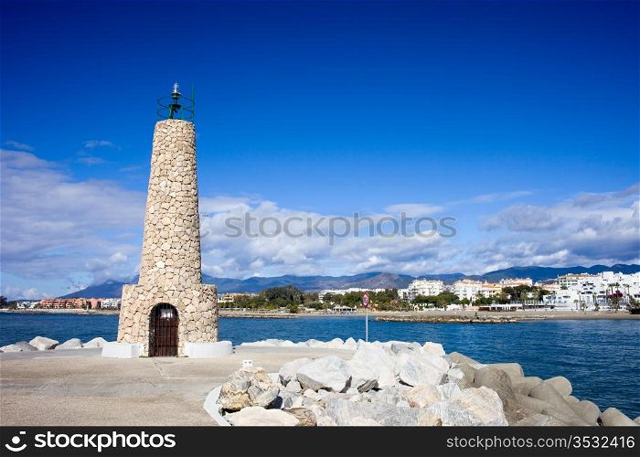 Stone lighthouse at the end of pier in Puerto Banus in Spain, southern Andalusia, Malaga province.